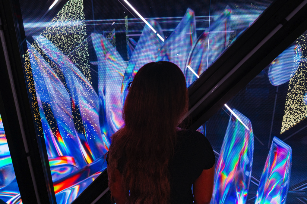 Person viewing colorful digital art installation at Edge NYC